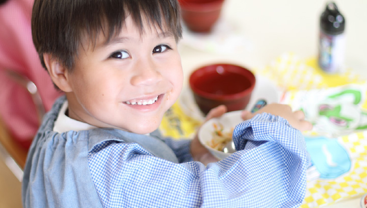 写真:給食を笑顔で食べている園児