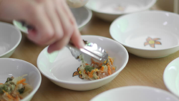 給食を盛り付ける写真